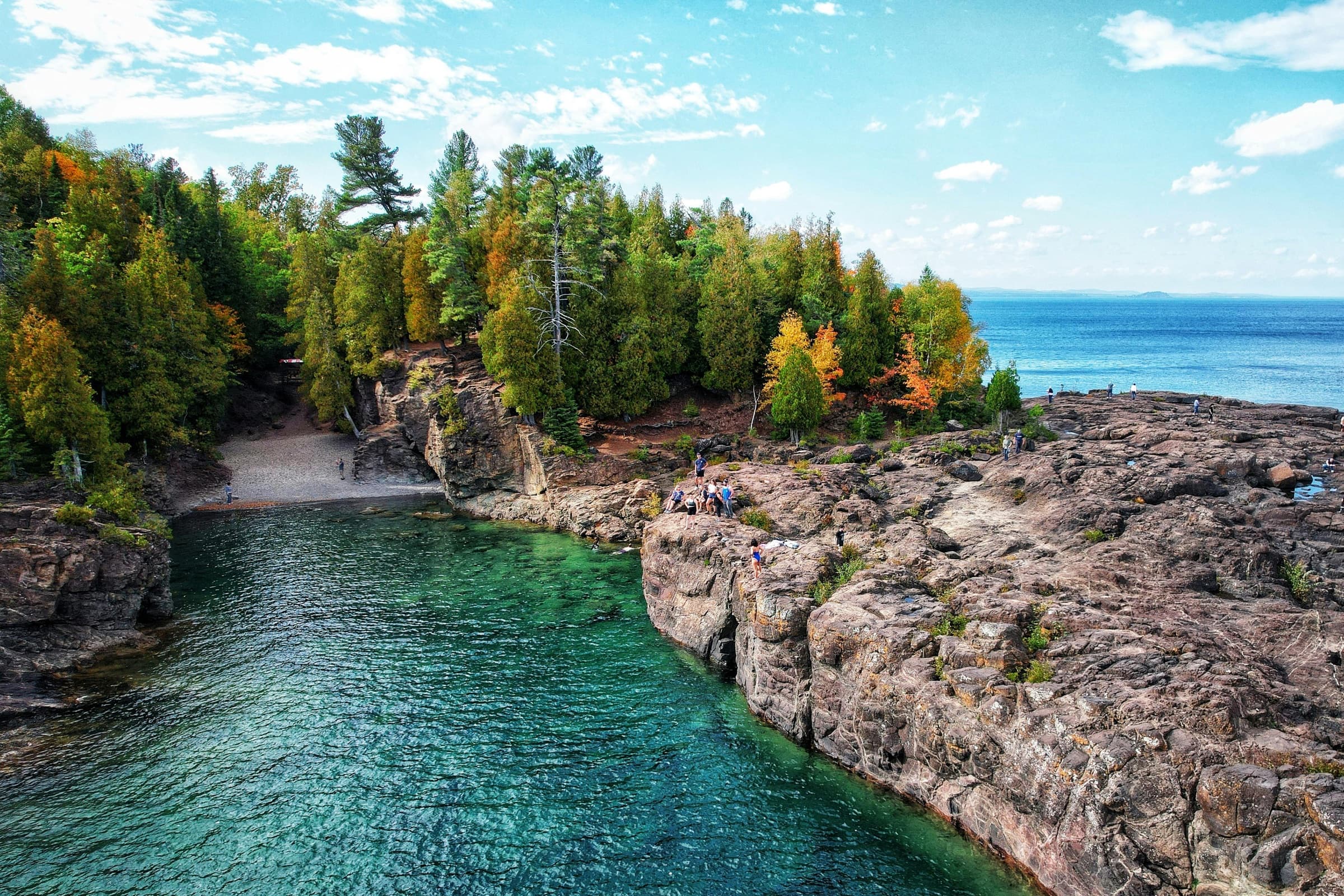 Visitors gathered on the rocks above the turquoise water at Pictured Rocks National Lakeshore